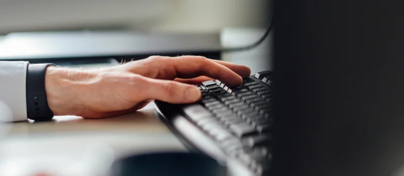 Eine Hand bedient eine Tastatur an einem Computerarbeitsplatz. Das Bild steht für den digitalen Zugriff auf Fachinformationen, Mitteilungen und Arbeitshilfen im Mitgliederportal des GVWE.